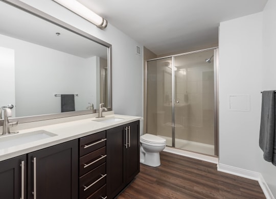 A bathroom with a toilet, sink, and shower at Clayton on the Park Apartments, Clayton, MO, 63105