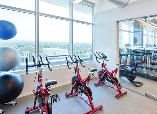 A gym with exercise bikes and a view of the city.
