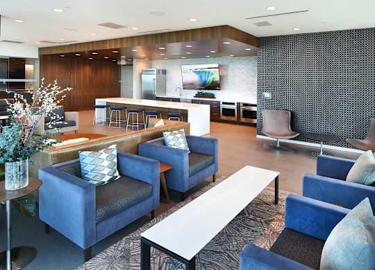 A modern living room with blue chairs and a white coffee table.