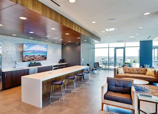 A modern kitchen with a bar and seating area.