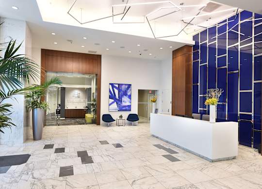A reception area with a white reception desk and a blue wall.