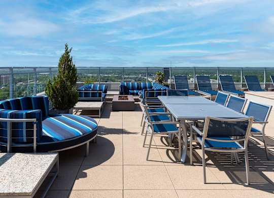 A patio with blue and white striped chairs and tables.