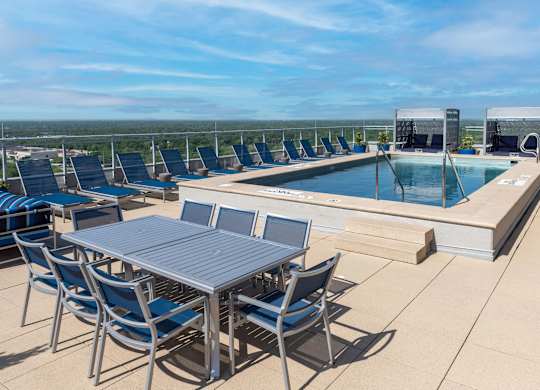 A table and chairs are set up on a patio overlooking a pool.