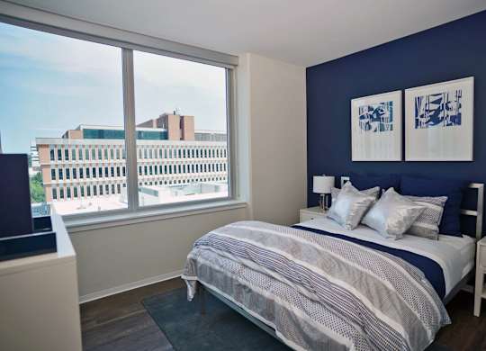 A bedroom with a large bed and a view of the city.