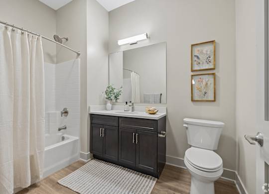 A bathroom with a white toilet, a white sink, and a white shower curtain.