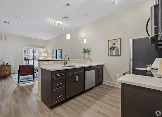 A kitchen with a white counter top and dark wood cabinets.