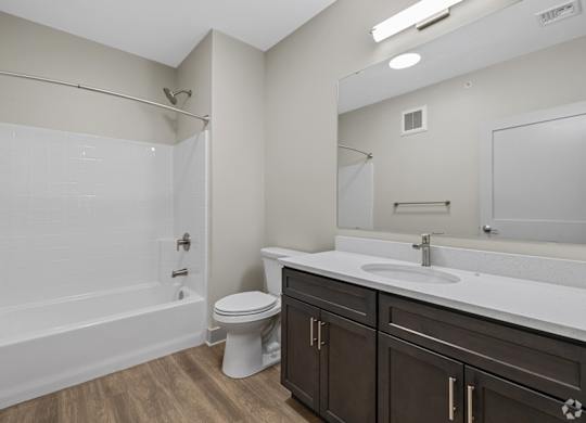 A white bathroom with a toilet, sink, and shower.