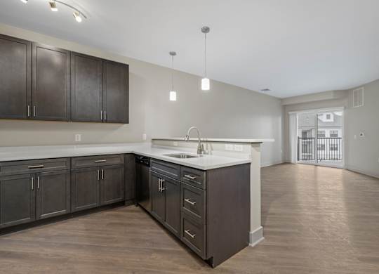 A kitchen with dark brown cabinets and a white countertop.