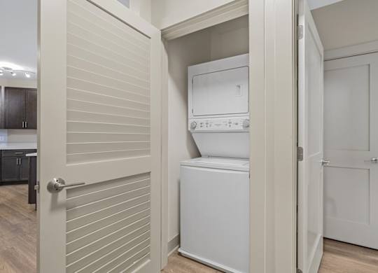 A white washing machine is in a small laundry room.