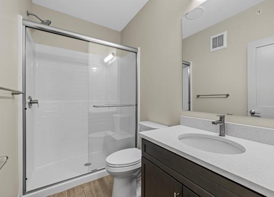 A bathroom with a toilet, sink, and shower.