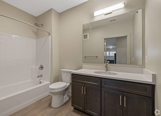 A white bathroom with a toilet, sink, and bathtub.