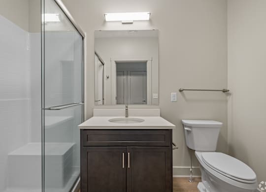 A bathroom with a toilet, sink, and shower.