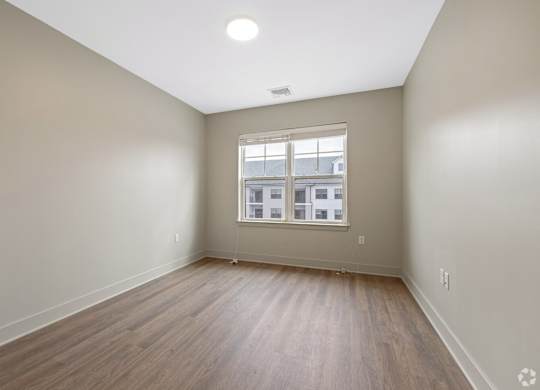 A room with wooden flooring and a window.