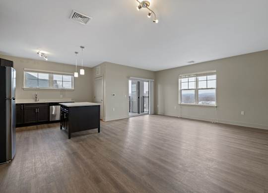A spacious kitchen with dark wood floors and a large island.