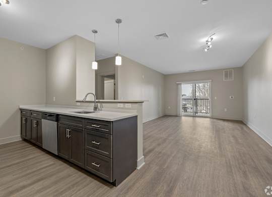 A spacious kitchen with dark wood cabinets and a white countertop.