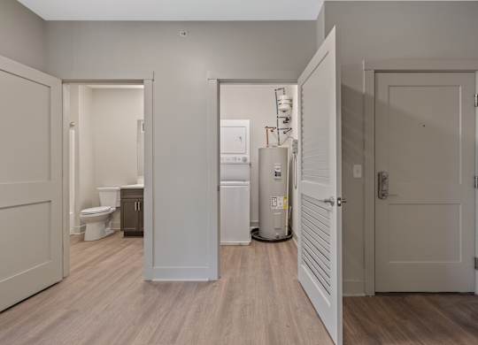 A white door is open to a bathroom with a toilet and sink.