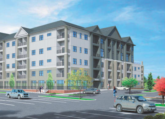 A large apartment building with a parking lot in front.
