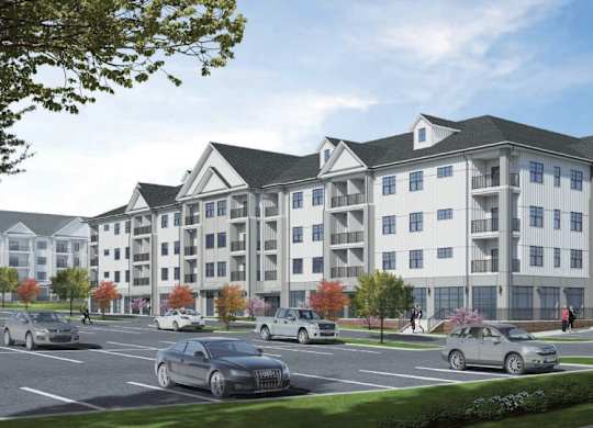 A large, modern apartment building with a parking lot in front.