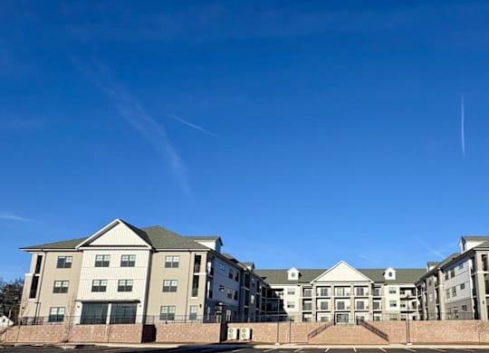 A large building with a green roof and a clear blue sky above it.