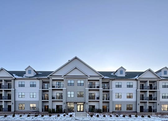 A large, multi-story residential building with a flat roof and multiple balconies.