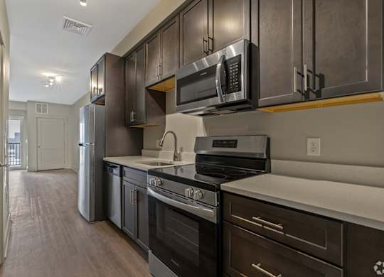 A kitchen with dark wood cabinets and stainless steel appliances.