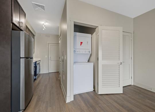A kitchen with a white fridge and a white door.