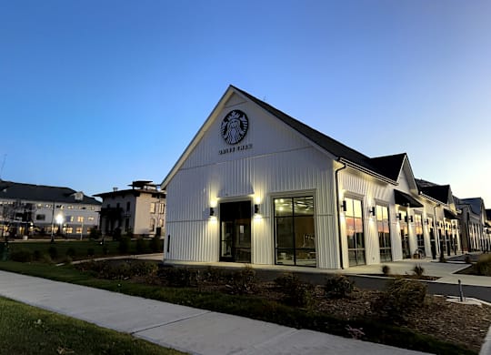 A Starbucks building is lit up at dusk.