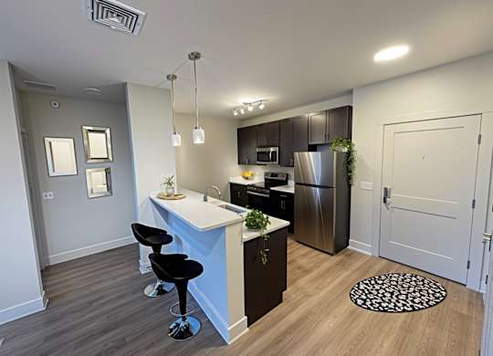 A kitchen with a white counter top and a refrigerator.