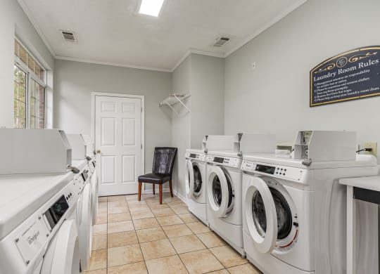 a laundry room with four washers and dryers and a door to a door at Litchfield Oaks Apartments, South Carolina