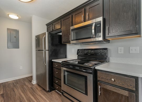 a kitchen with black appliances and wooden cabinets and a stainless steel refrigerator