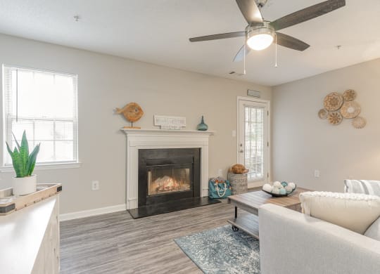 a living room with a fireplace and a ceiling fan at Litchfield Oaks Apartments, Pawleys Island, 29585