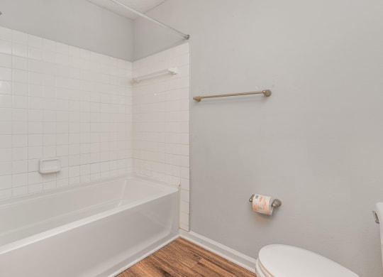 a white bathroom with a tub and a toilet