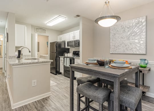 our model home has an open floor plan with a dining room table and a kitchen at Litchfield Oaks Apartments, Pawleys Island, SC