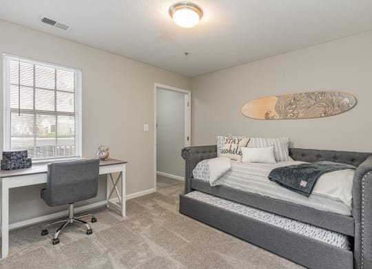 a bedroom with a bed and a desk and a window at Litchfield Oaks Apartments, South Carolina