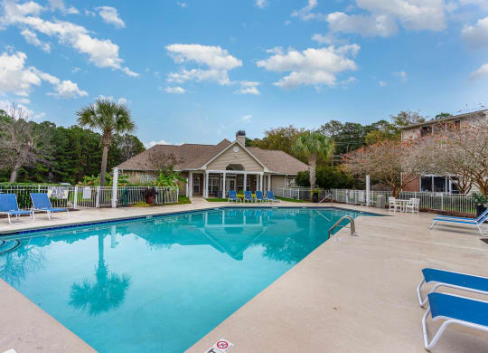 a swimming pool with a house in the background at Litchfield Oaks Apartments, South Carolina