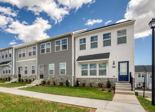 A row of modern townhouses with a sidewalk in front at The Mark Townhomes Apartments, Harrisonburg, Virginia