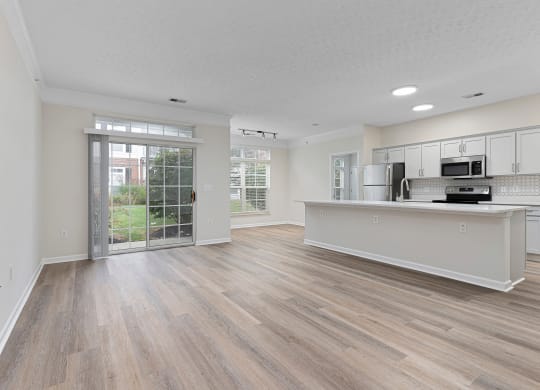 an open living room and kitchen with a door to a patio  at The Charleston, Columbus