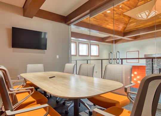 A conference room with a large table and chairs.
