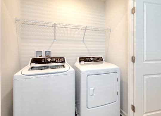 Two white front load washing machines in a laundry room at The Mark Townhomes Apartments, Harrisonburg, VA