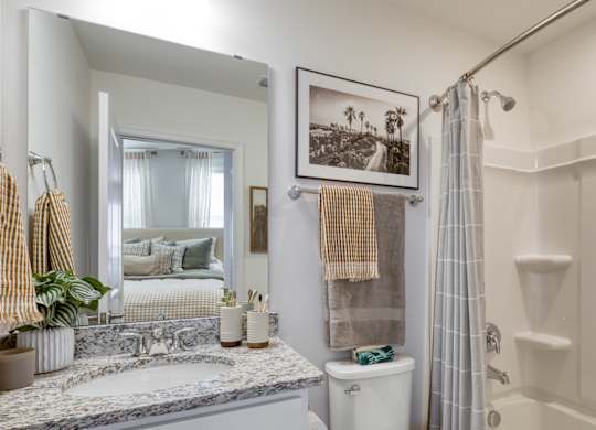 A bathroom with a marble countertop and a shower with a glass door at The Mark Townhomes Apartments, Harrisonburg, VA, 22801