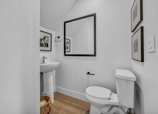 A white toilet sits next to a sink in a small bathroom.