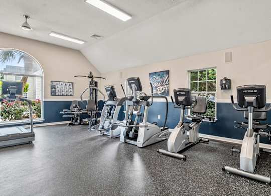 A gym with treadmills, exercise bikes, and elliptical machines.