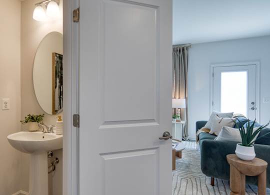A bathroom with a white sink and a mirror on the wall at The Mark Townhomes Apartments, Virginia, 22801