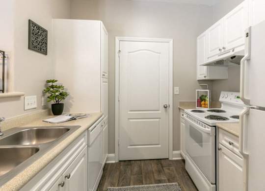 A small white kitchen with a sink and a stove.