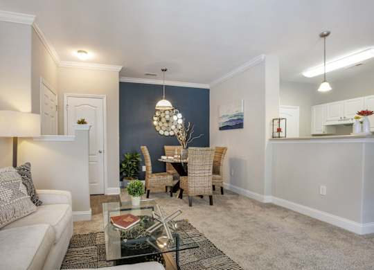a living room and dining room with a table and chairs
