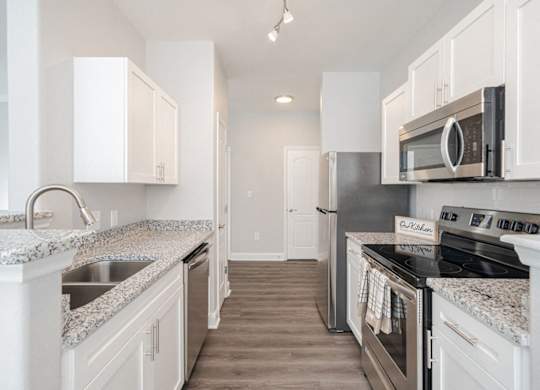 a kitchen with granite counter tops and stainless steel appliances