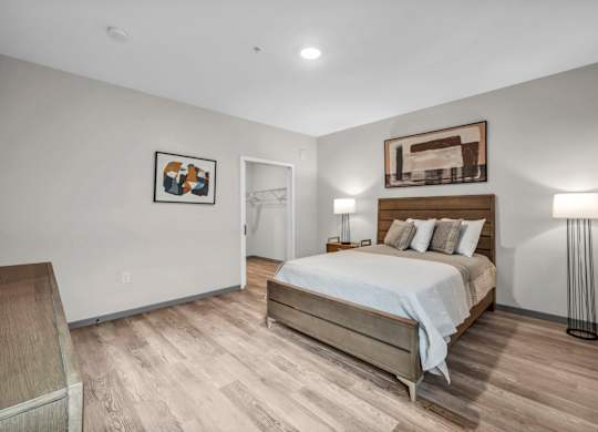 A bedroom with a bed, nightstand, and lamp.