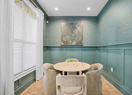 A dining room with a round table and chairs.