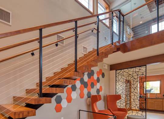 A staircase with a metal railing and wooden steps.