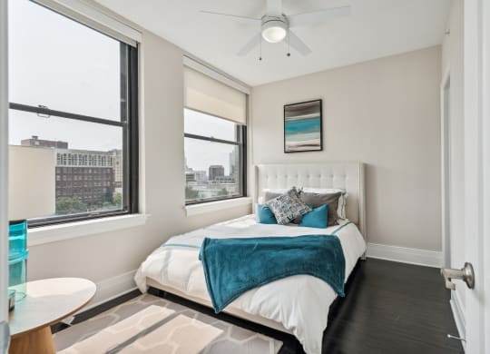 a bedroom with a bed and two windows